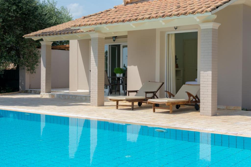 a villa with a swimming pool and a patio at Villa Nefeli Breeze in Dassia