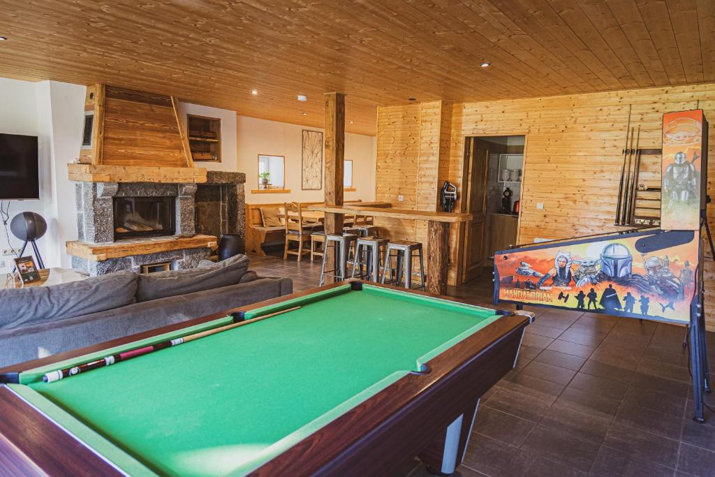 a living room with a pool table and a fireplace at La Charbonnière, grand gîte haut-de-gamme avec jacuzzi et sauna in Gérardmer