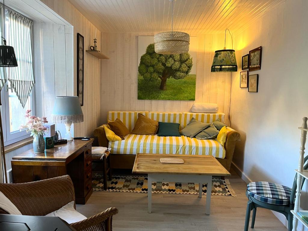 a living room with a yellow couch and a table at La p'tite Maison in Vitrac