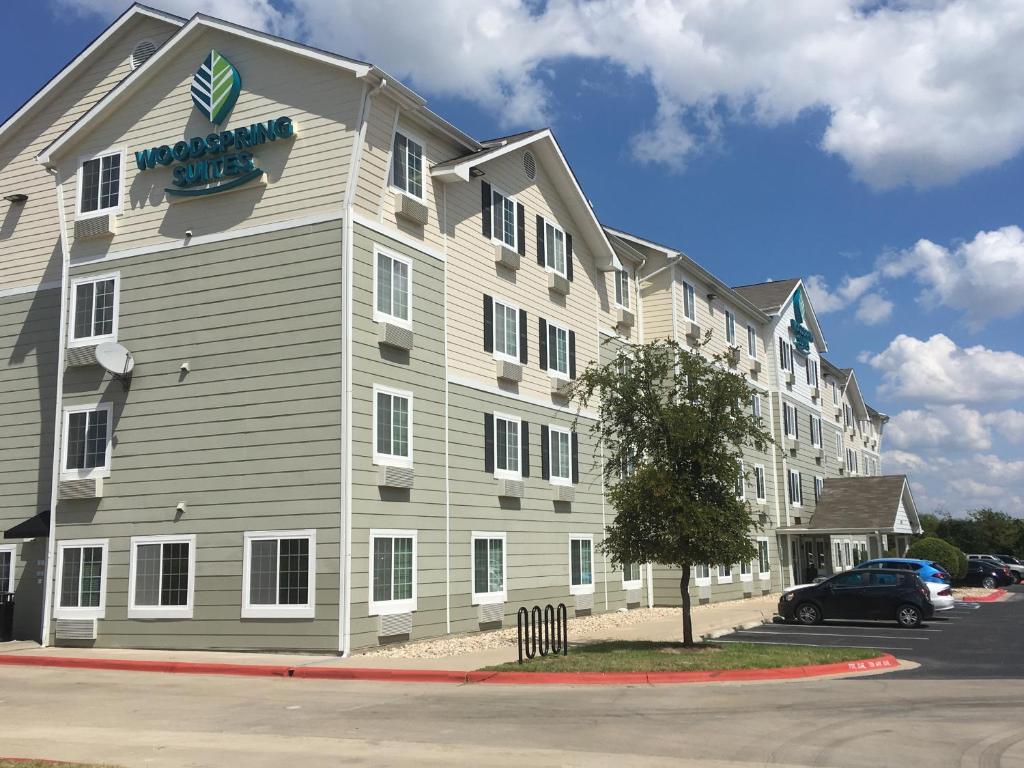 
a large white building with a blue sky at WoodSpring Suites Dickinson in Dickinson
