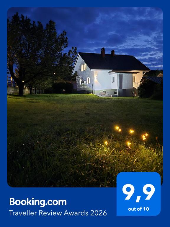a house with lights in a yard at night at Aparthouse Jana Breg in Žirovnica