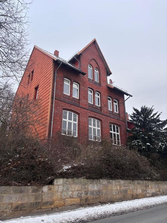 a red brick house with white windows on a street at Emmerstedt - Alte Schule in Helmstedt