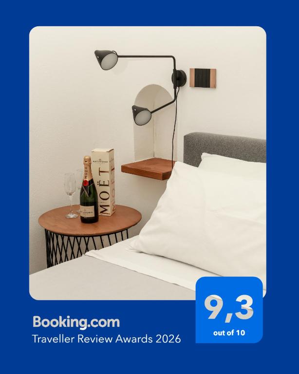 a bottle of wine on a table next to a bed at Dislocati BnB - Jacuzzi privata - Cucina - TV60" - Minimal Luxury in Marigliano