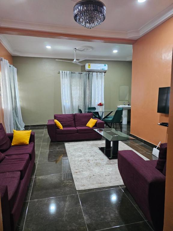 a living room with purple couches and a table at Gifted Estates in Accra