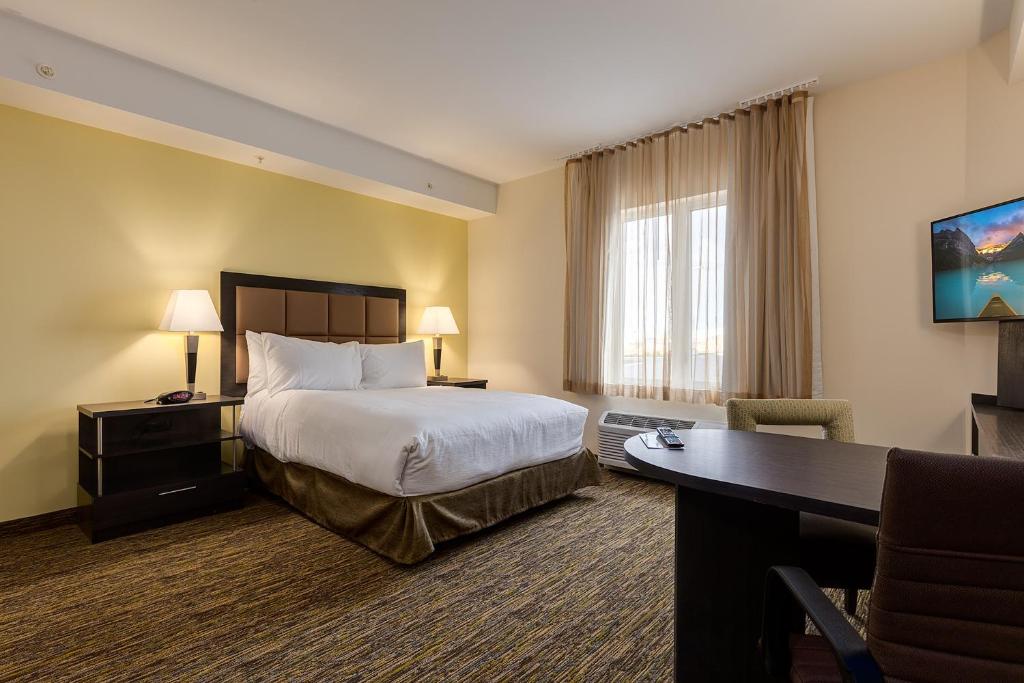 a hotel room with a bed and a desk at Park Inn by Radisson, Calgary Airport North, AB in Calgary