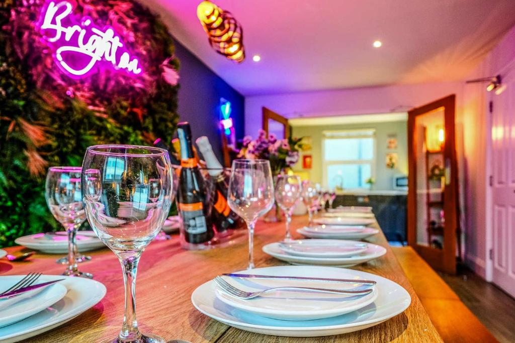 a long table with wine glasses and plates on it at West Pier Beach - by Brighton Holiday Lets in Brighton & Hove