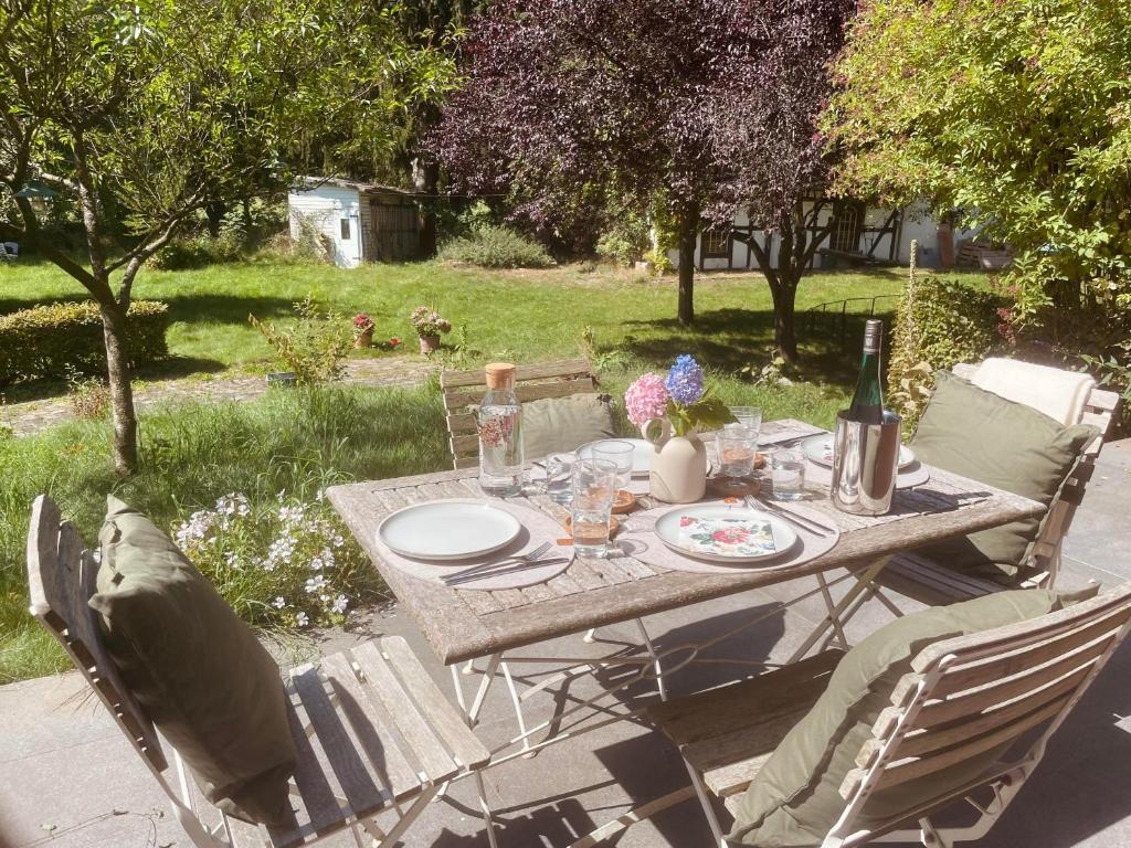 a picnic table in a yard with a bottle of wine at Ferienwohnung Anstois in Kall