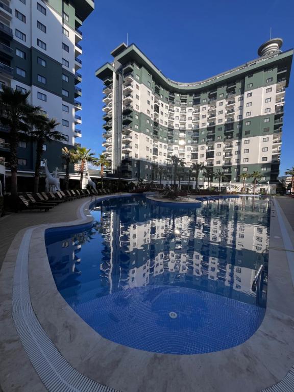 a swimming pool in front of a building at Serenity Residence duplex in Alanya