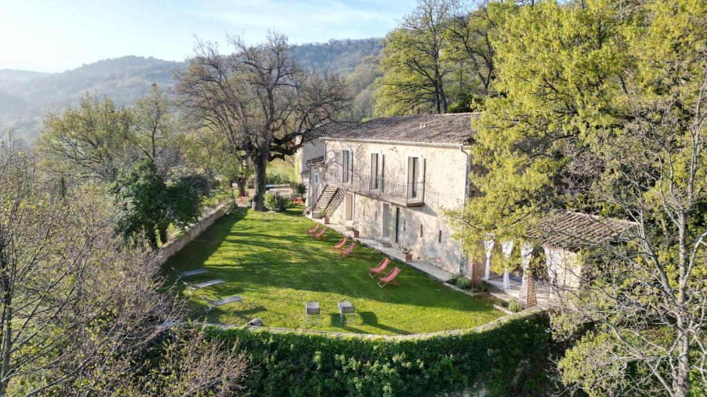 an old stone house with a garden and trees at Domaine des Druides in Apt