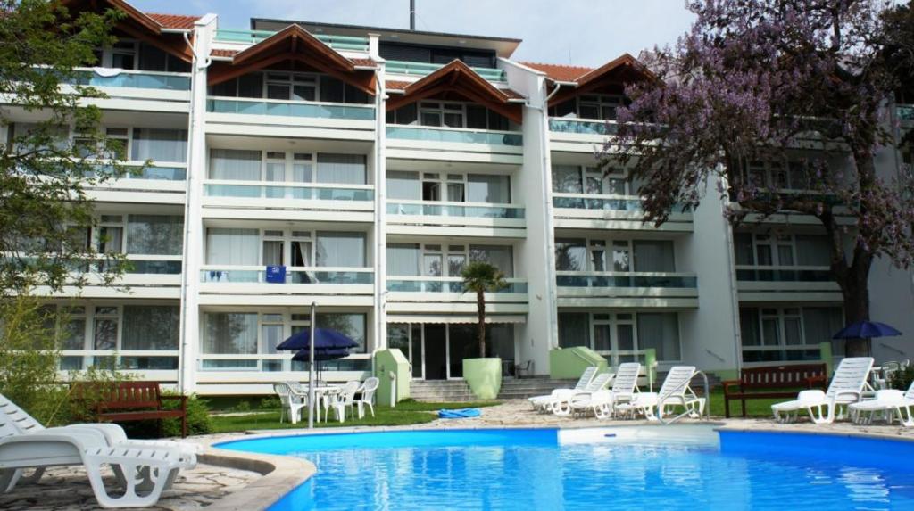 an exterior view of a hotel with a swimming pool at Holiday Art Garden&Spa in Balatonfüred