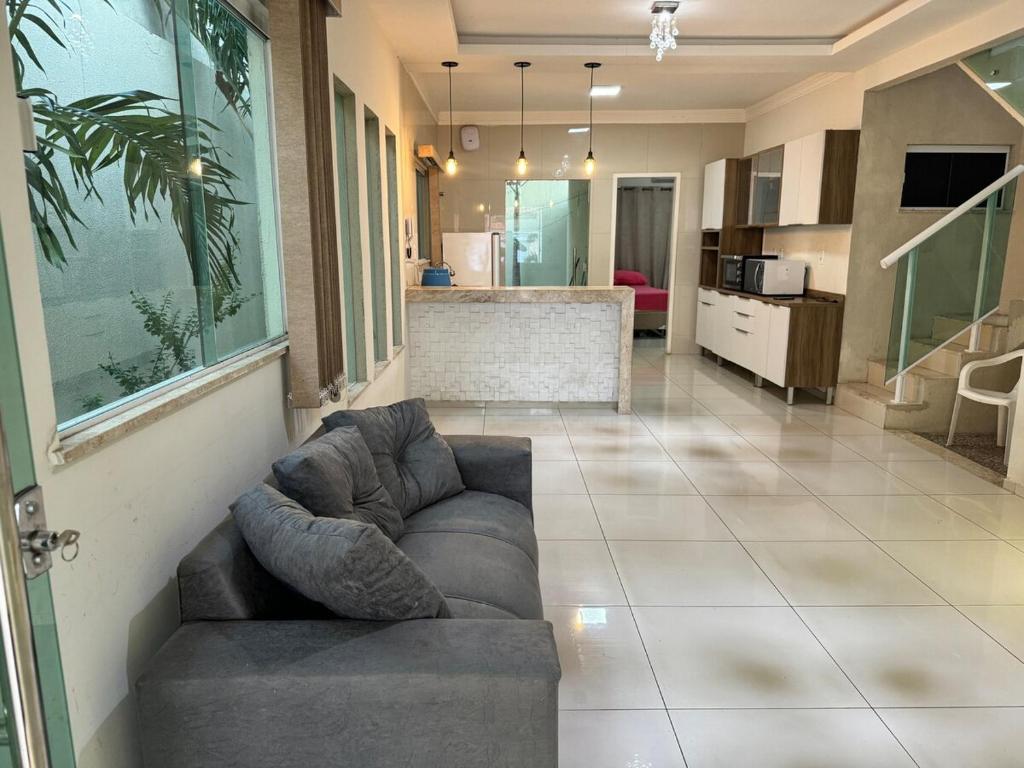 a living room with a couch and a kitchen at Casa completa com 3 quartos,ar e garagem in Sobral