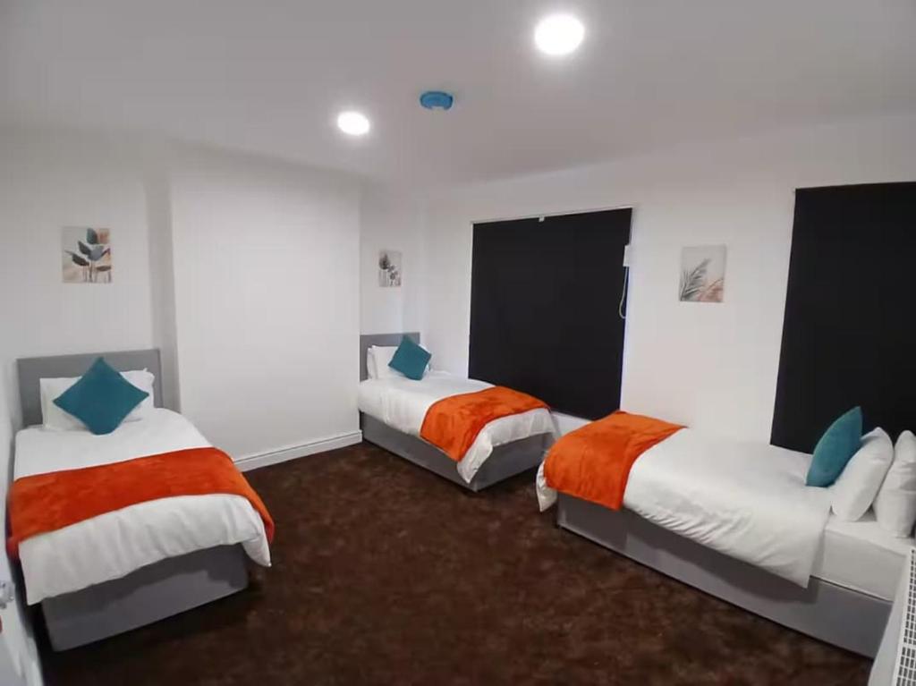 a bedroom with two beds and a couch at Lincoln Manor 5BR in Peterborough