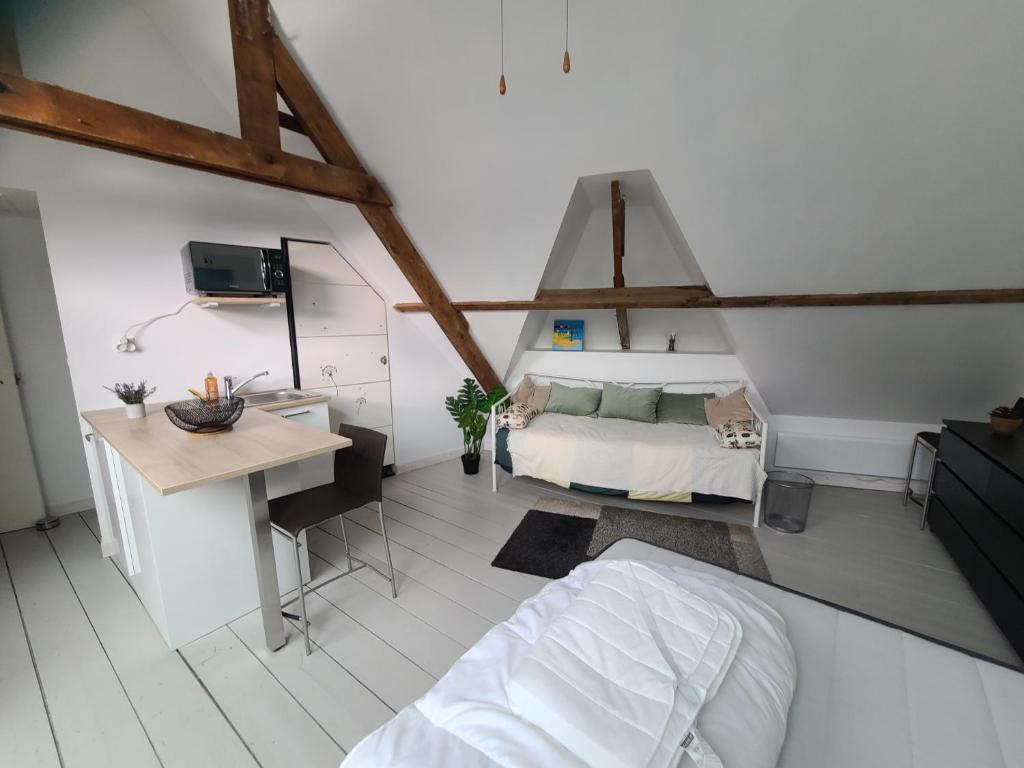 a bedroom with a bed and a desk in a room at Le nid de Marceline in Lannion