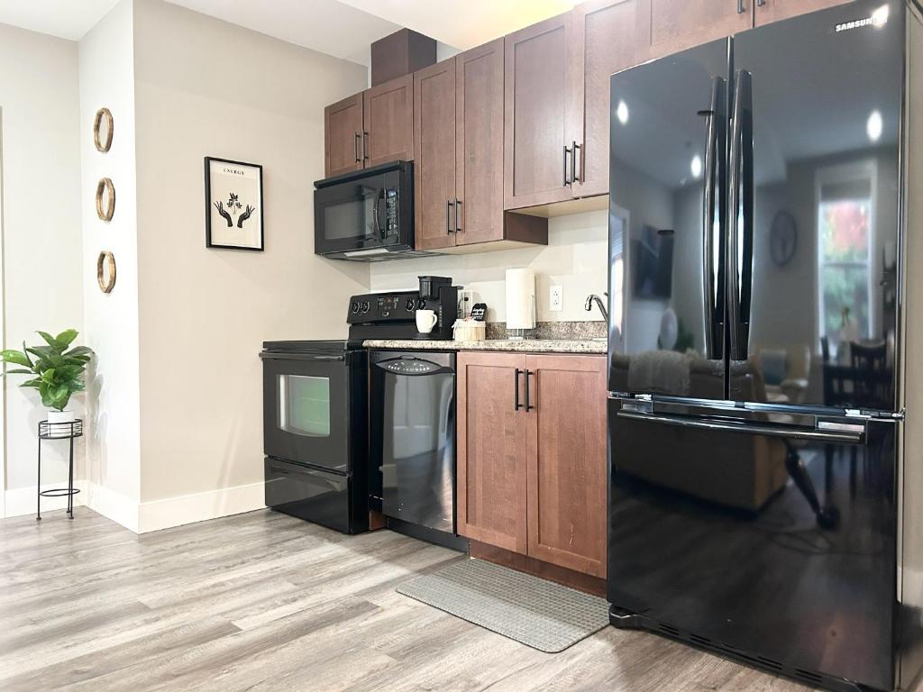 a kitchen with black appliances and wooden cabinets at 92179 Newfoundland & Labrador Limited in St. John's