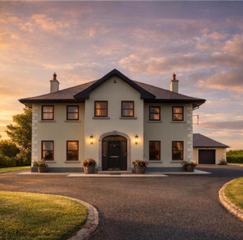 a large white house with a driveway at Country Hideaway in Limerick