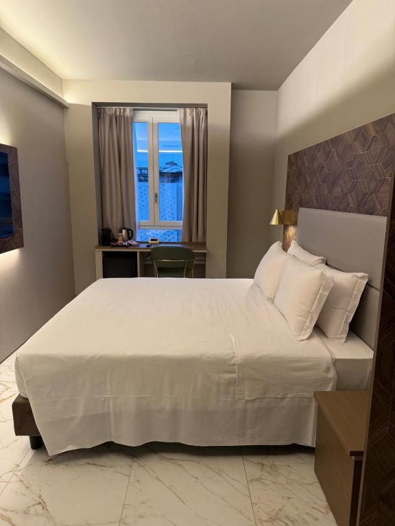 a bedroom with a large white bed with a window at Baires Guest House 2 in Milan