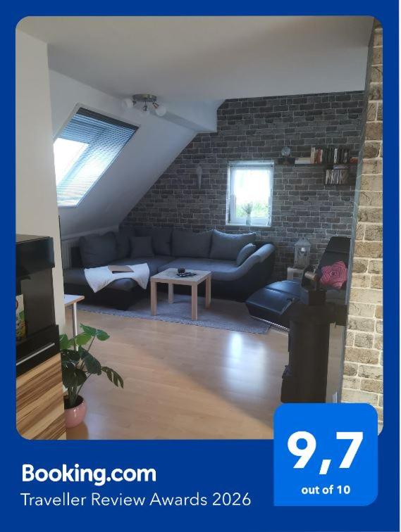 a living room with a couch and a brick wall at Ferienwohnung Grünberger Land in Grünberg