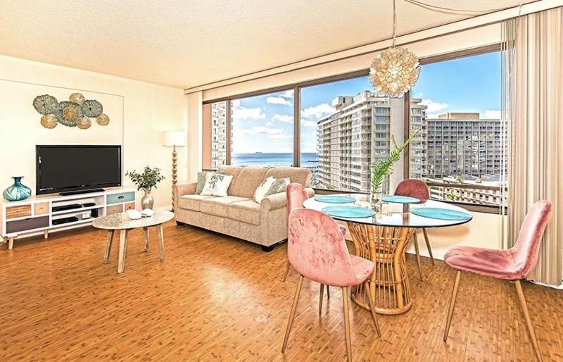 a living room with a couch and a table with chairs at Discovery Bay 1419 in Honolulu