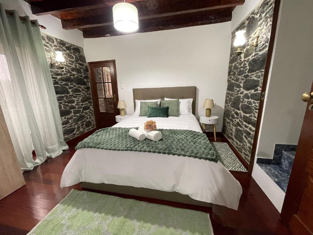 a bedroom with a bed with two towels on it at Casa Gouveia in Ribeira Brava