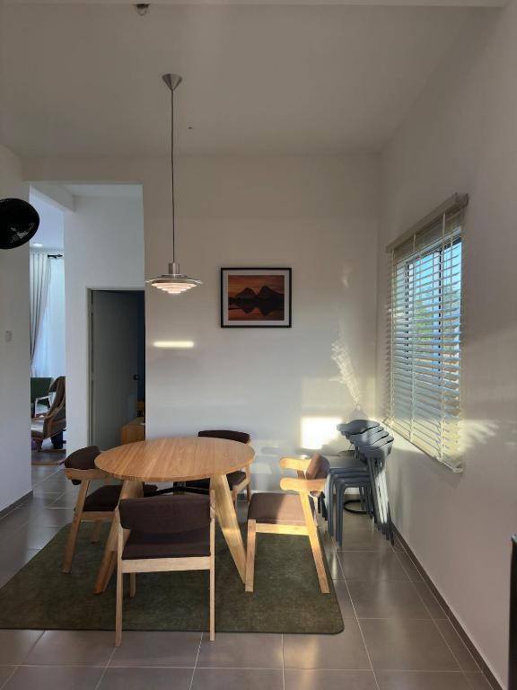a dining room with a wooden table and chairs at Deyrina Home in Arau