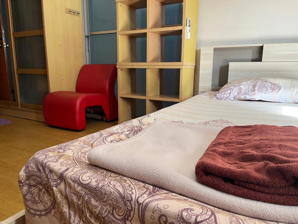 a bedroom with a bed and a red chair at Impact Arena C4 by Jintana in Ban Bang Phang