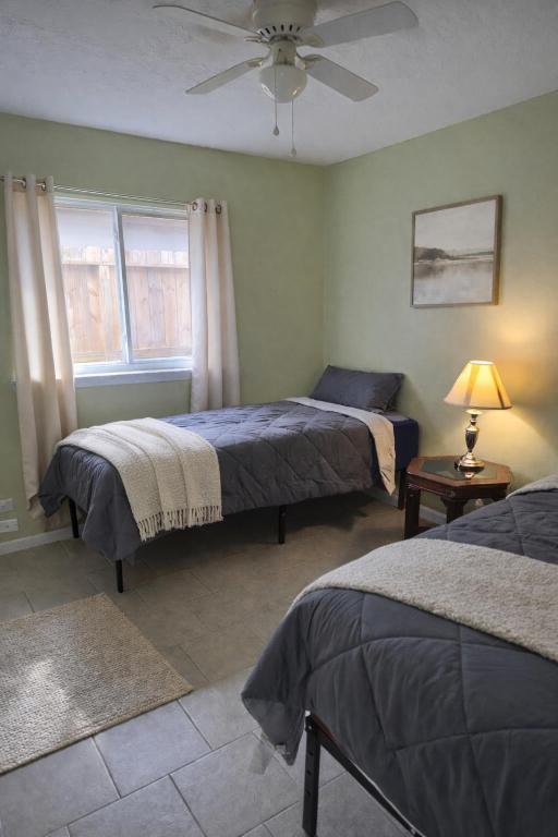 a bedroom with two beds and a ceiling fan at Fresh Crash Pads 4-Affordable Shared Housing in Houston