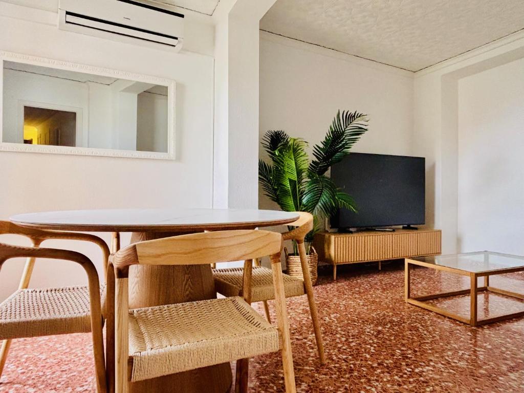 a living room with a table and chairs and a tv at Cosy Flat Catarroja in Catarroja