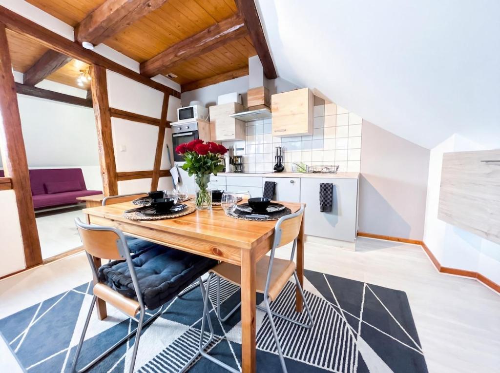 a kitchen and dining room with a wooden table and chairs at Duplex de Charme - Turckheim - Route des Vins in Turckheim