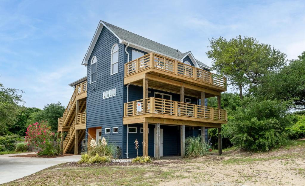 a large blue house with a deck at Climate Change - Duck, Sea Tern, Oceanside, 280 Yds to Beach, Pool, Hot Tub, Pets OK in Duck