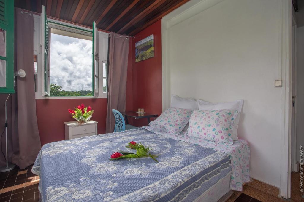 a bedroom with a bed with flowers on it at Villa Les Violettes in Morne-à-lʼEau