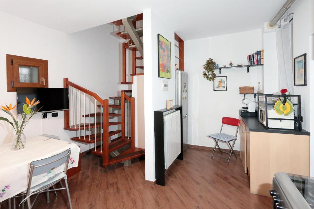 a kitchen and a living room with a table and chairs at Casa l'Apina Regina in Capriate San Gervasio
