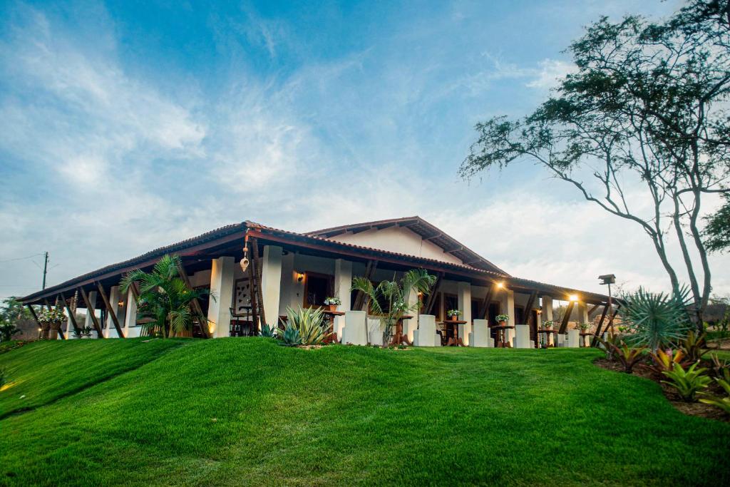 a house with a green lawn in front of it at A Flor Pousada in Garanhuns