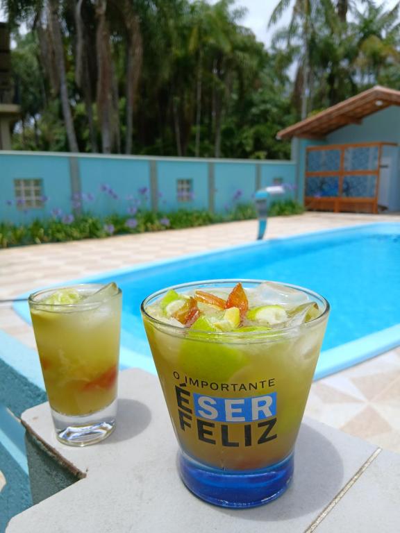 a drink sitting on a table next to a pool at Casa de Campo com piscina in Mairinque