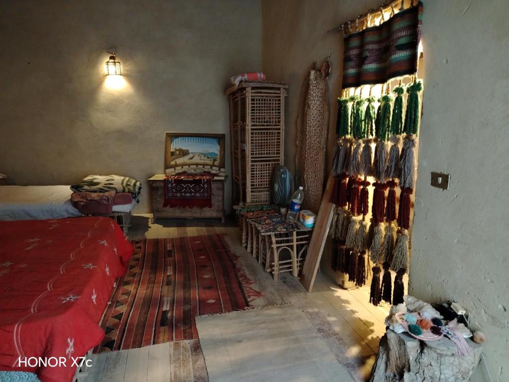 a room with a bed and a shelf of bottles at Siwa Shaly in Siwa
