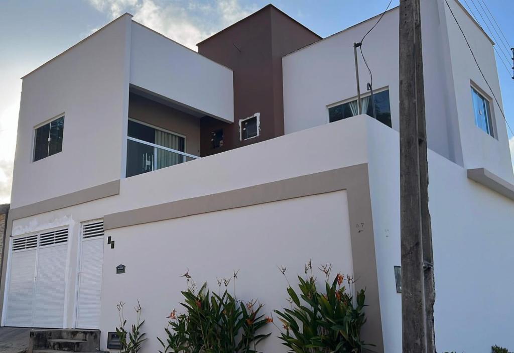 a white house with a large garage at Casa em Dunas de Marapé -Jequia da praia in Jequia da Praia