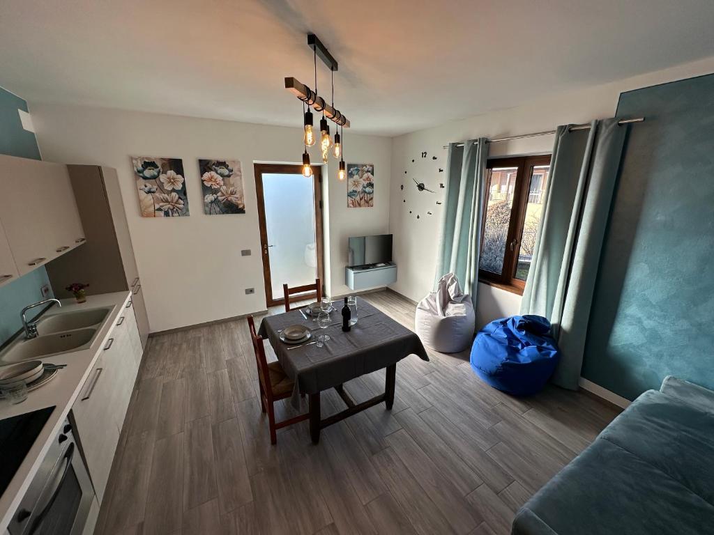 a living room with a table and a kitchen at Casa Rosetta in Tignale