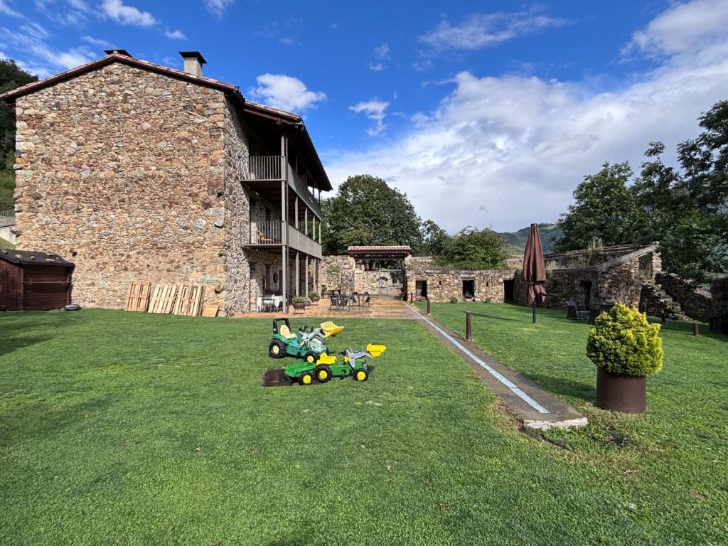 a group of stuffed animals sitting on the grass in front of a building at La Casassa de Ribes in Ribes de Freser