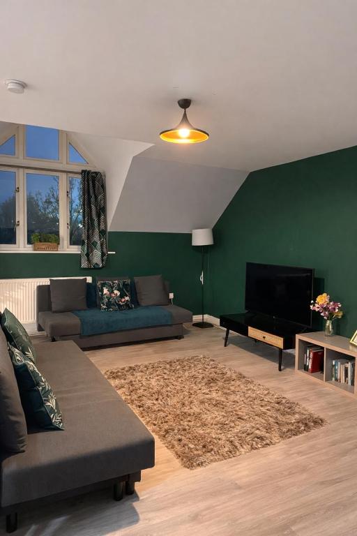 a living room with a couch and a flat screen tv at Modern Spacious Flat In Ipswich - Sleeps 6 - Parking in Freston