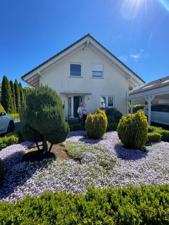 a man standing in front of a house with bushes at FeWo Track n Chill in Windhagen
