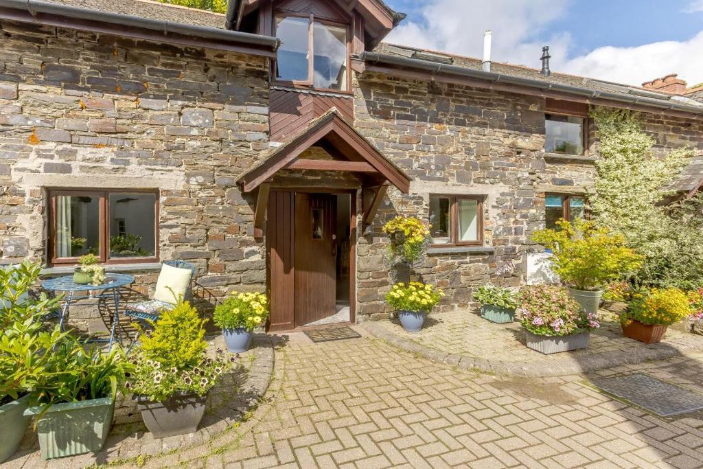 a stone house with potted plants in front of it at 2 Bed in Swimbridge oc-n0208 in Swimbridge