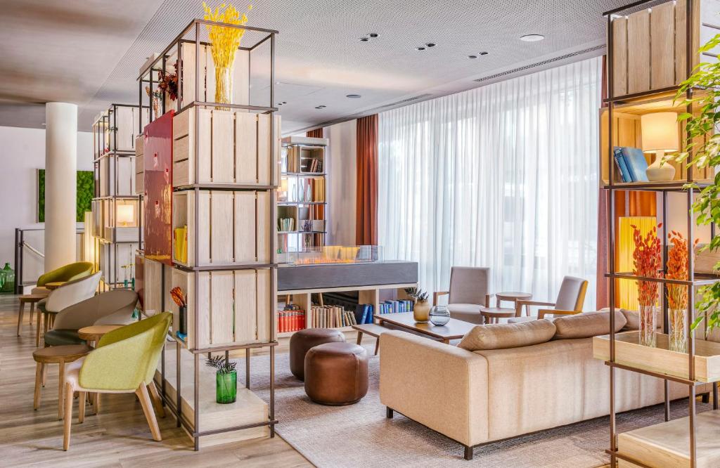 a living room with a couch and chairs at Hotel Nürnberg City Center by Leonardo Hotels in Nuremberg