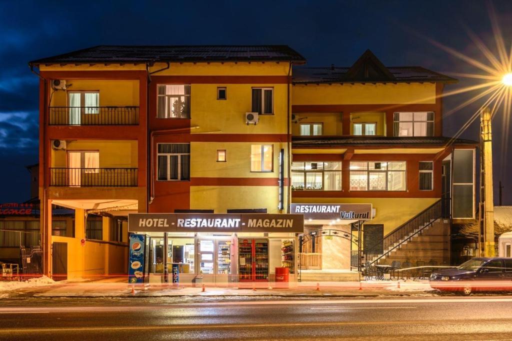 a building on the side of a street at night at Hotel VULTURUL Pitesti in Piteşti