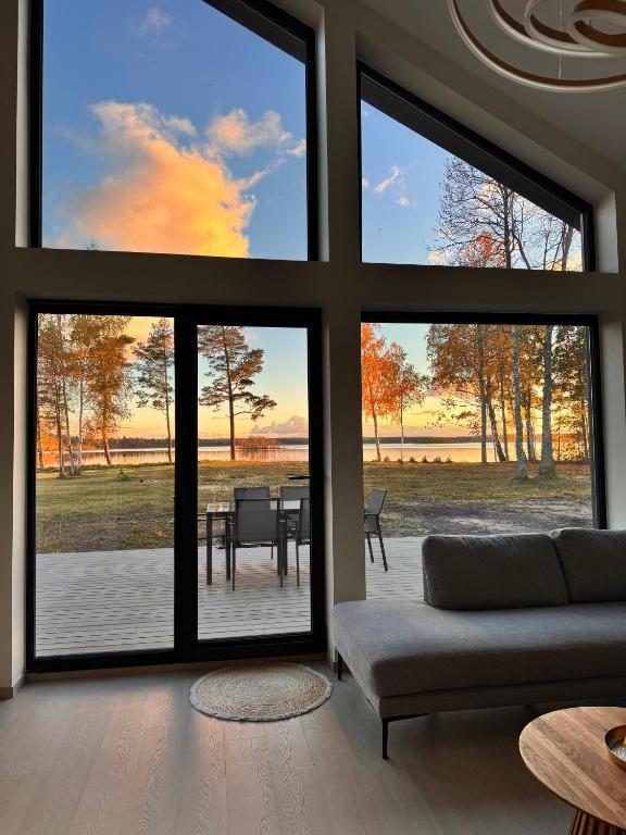 a living room with large windows and a couch at Järvemetsa Stay in Dejevo