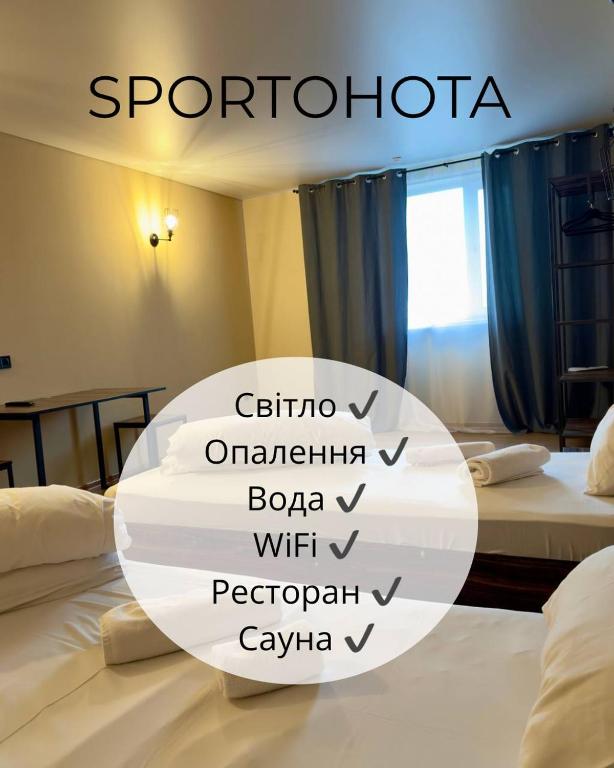 a hotel room with two beds with the words sputoria at Спортохота in Cherkasy