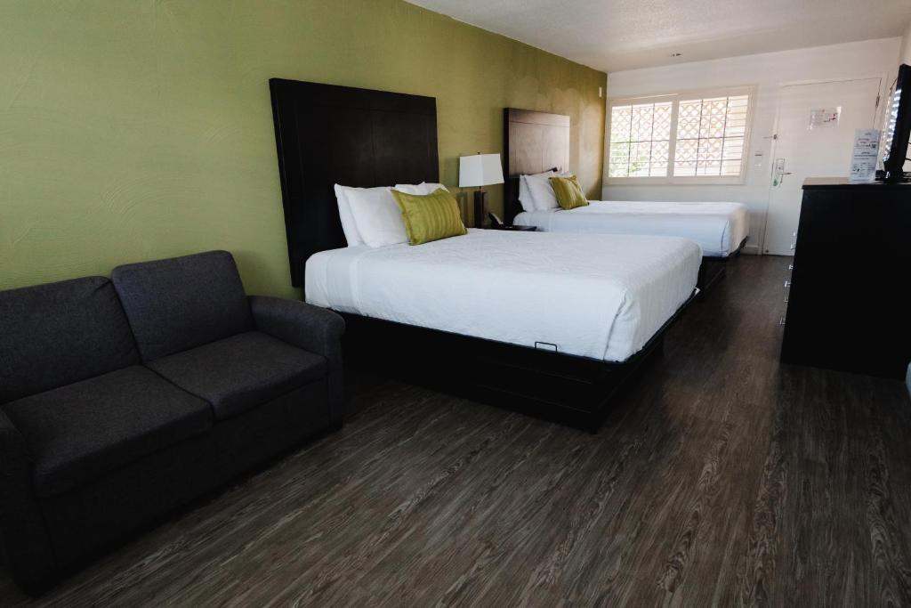 a hotel room with two beds and a couch at Old Town Western Inn in San Diego