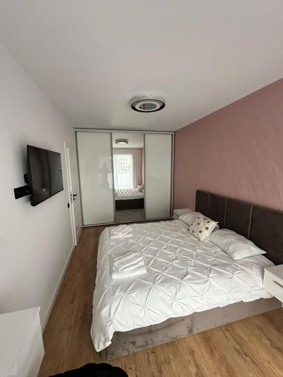 a bedroom with a large bed and a flat screen tv at Sara Home in Baia Mare