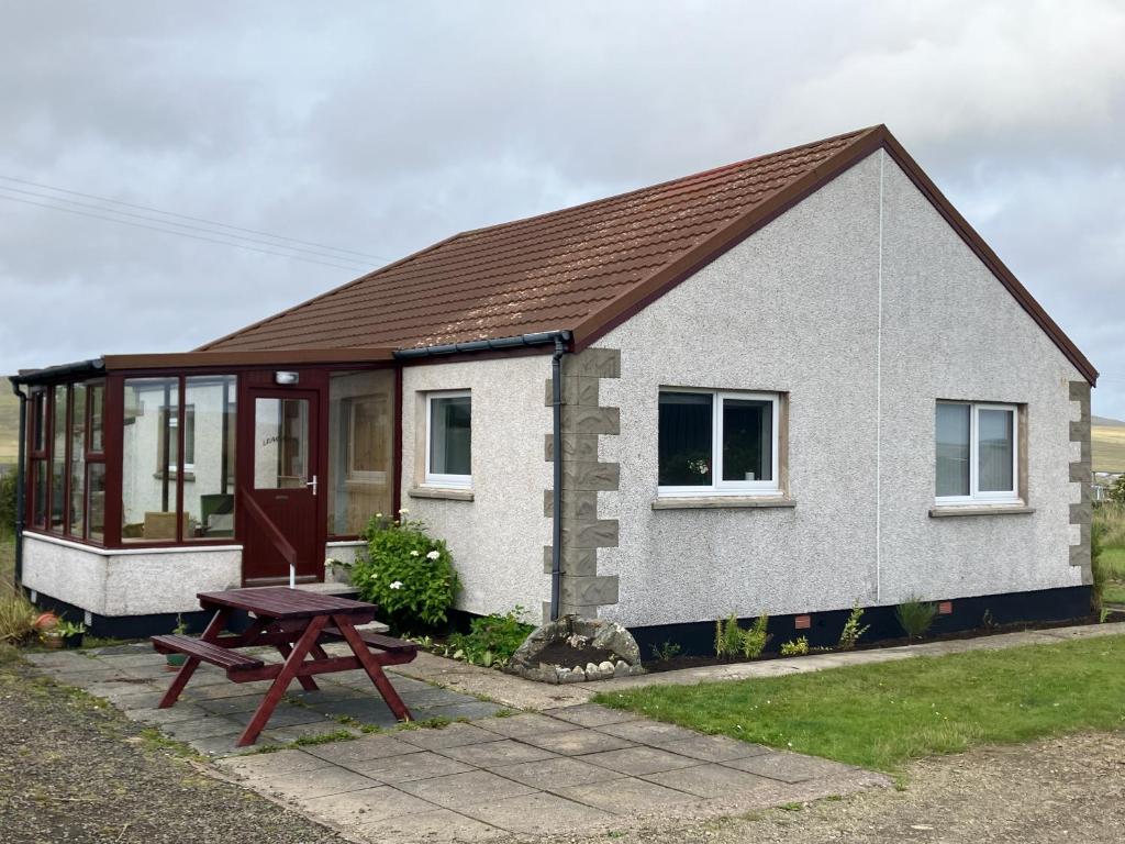 a small house with a picnic table in front of it at Leagarth House in Baltasound