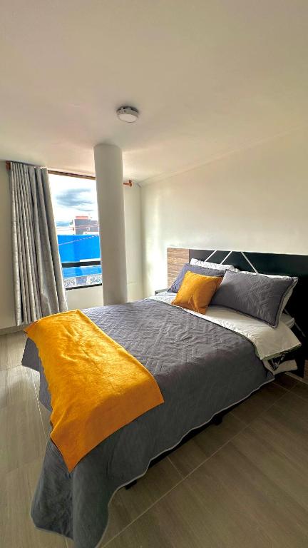 a bedroom with a large bed with a large window at LourdesInn65 in Bogotá
