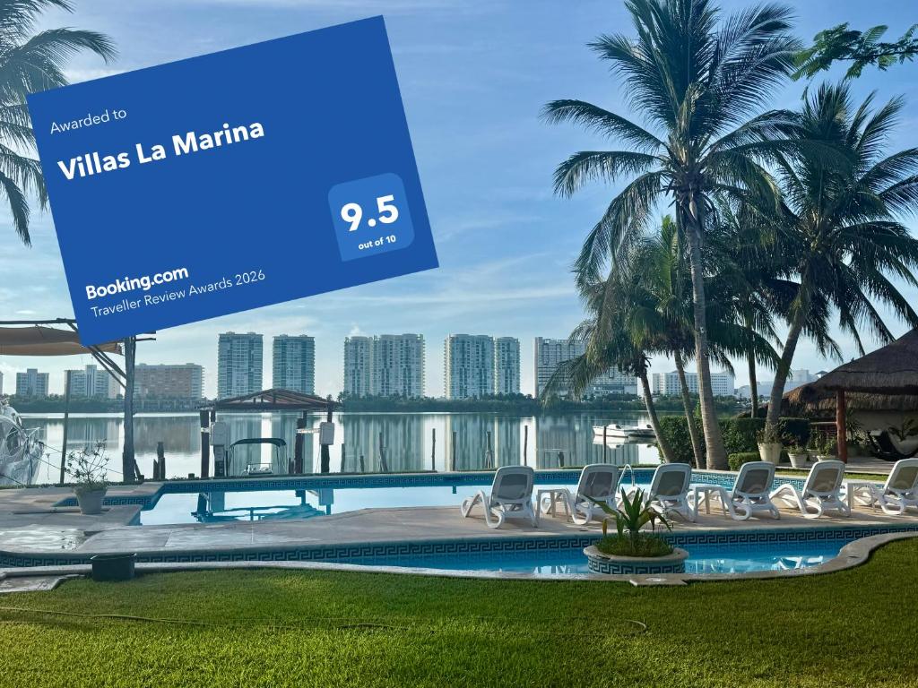 a sign in front of a swimming pool with chairs at Villas La Marina in Cancún