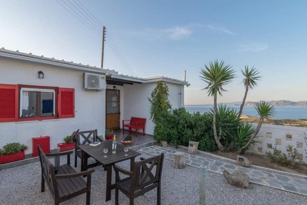 a patio with a table and chairs in front of a house at Dust in The Wind Sunrise in Triovasálos